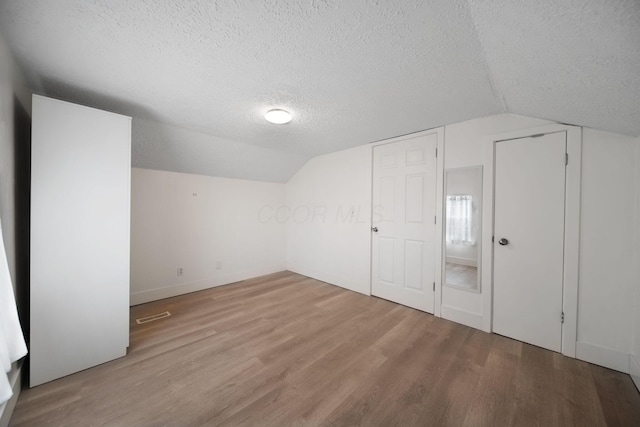 173 Highland Ave, Buckeye Lake, OH 43008 - additional living space with a textured ceiling, lofted ceiling, wood finished floors, and baseboards