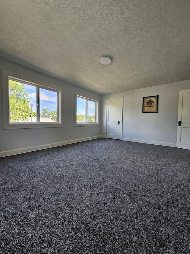 2889 E 12th Ave, Columbus, OH 43219 - empty room featuring baseboards, a textured ceiling, and dark colored carpet