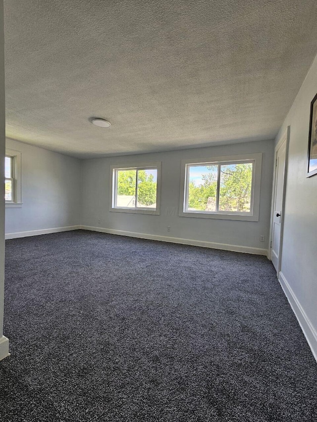 2889 E 12th Ave, Columbus, OH 43219 - unfurnished room with dark colored carpet, a textured ceiling, and baseboards