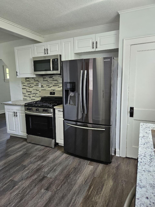 2889 E 12th Ave, Columbus, OH 43219 - kitchen with stainless steel appliances, dark wood-type flooring, white cabinets, decorative backsplash, and crown molding