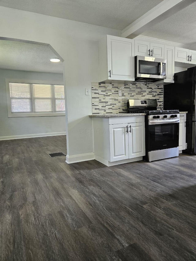2889 E 12th Ave, Columbus, OH 43219 - kitchen featuring stainless steel appliances, a textured ceiling, tasteful backsplash, white cabinetry, and dark wood finished floors