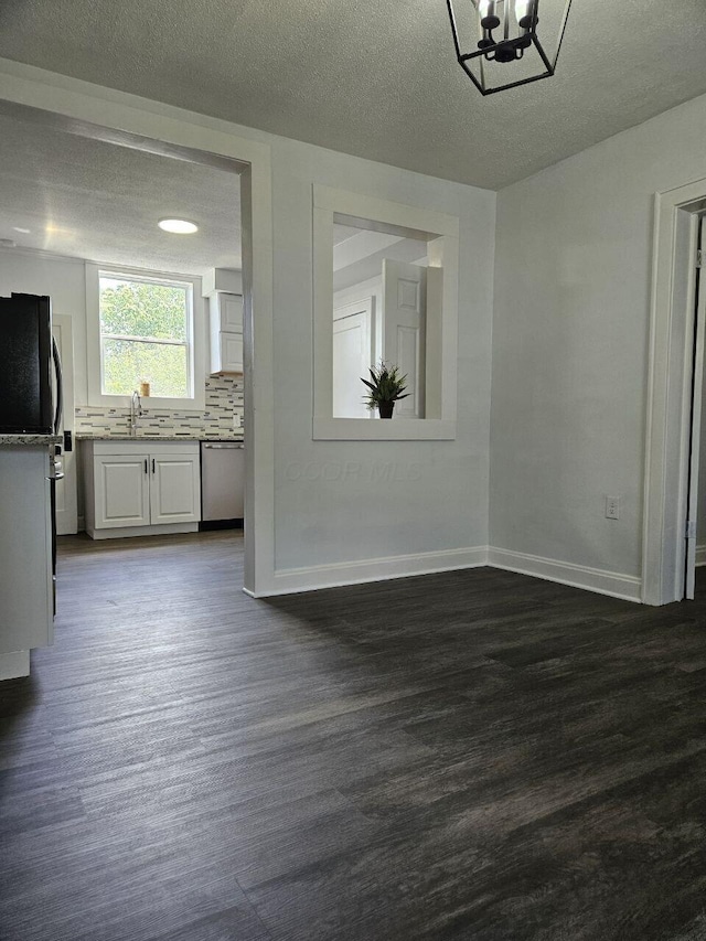 2889 E 12th Ave, Columbus, OH 43219 - unfurnished dining area featuring a sink, dark wood-style flooring, baseboards, a textured ceiling, and a chandelier