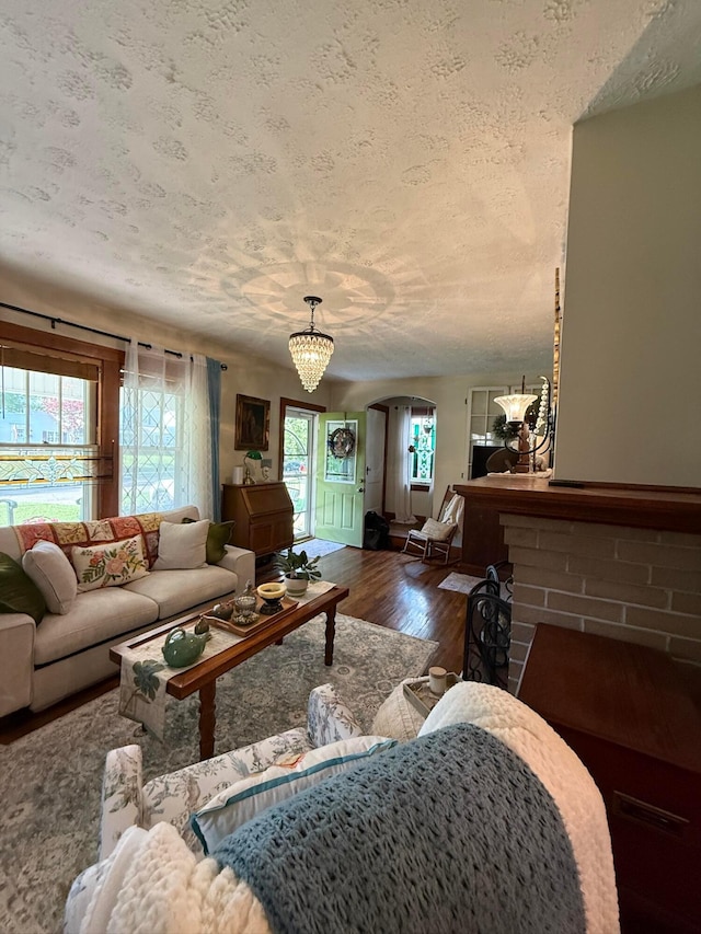 550 E Allen St, Lancaster, OH 43130 - living room featuring healthy amount of natural light, dark wood-style flooring, arched walkways, a textured ceiling, and a brick fireplace