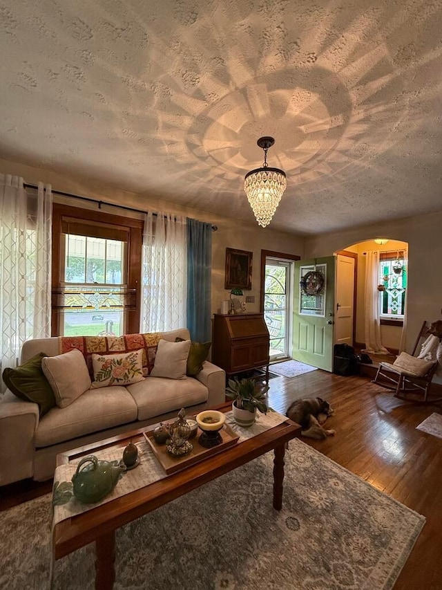 550 E Allen St, Lancaster, OH 43130 - living room featuring a textured ceiling, a chandelier, dark wood-style floors, and arched walkways