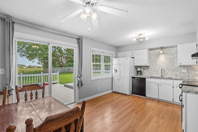 5690 Brinkley Ct, Columbus, OH 43235 - kitchen featuring white refrigerator with ice dispenser, black dishwasher, decorative backsplash, a textured ceiling, and light wood-style floors
