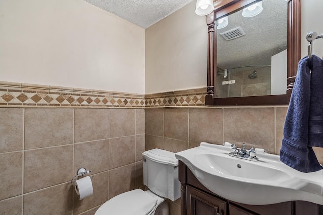 5690 Brinkley Ct, Columbus, OH 43235 - full bath with a textured ceiling, tile walls, vanity, a shower, and a wainscoted wall