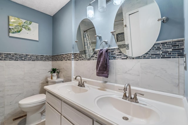 5690 Brinkley Ct, Columbus, OH 43235 - full bathroom featuring tile walls, double vanity, curtained shower, and a wainscoted wall