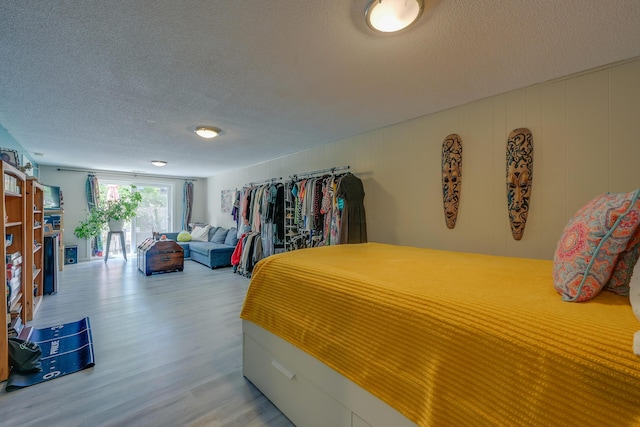 655 Providence Ave Unit 9-655J, Columbus, OH 43214 - bedroom with light wood-style flooring, a textured ceiling, and access to outside