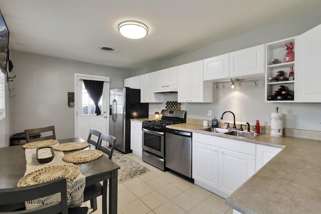 1015 Westview Dr, Hebron, OH 43025 - kitchen with appliances with stainless steel finishes, under cabinet range hood, white cabinetry, light countertops, and light tile patterned flooring