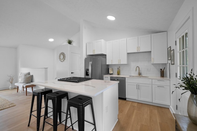 1047 Cherry Bud Dr, Columbus, OH 43228 - kitchen with appliances with stainless steel finishes, a sink, lofted ceiling, a center island, and a kitchen bar
