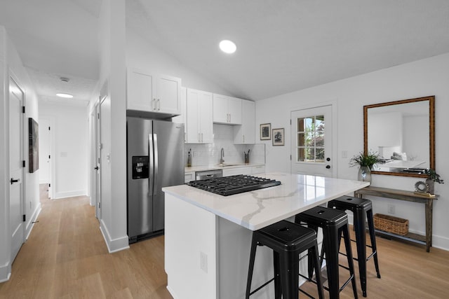 1047 Cherry Bud Dr, Columbus, OH 43228 - kitchen with stainless steel appliances, light wood-style floors, a kitchen breakfast bar, white cabinetry, and a kitchen island