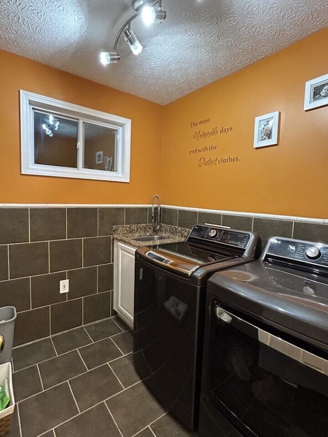 5321 Longshadow Dr, Westerville, OH 43081 - washroom featuring cabinet space, tile walls, washer and clothes dryer, dark tile patterned floors, and a textured ceiling