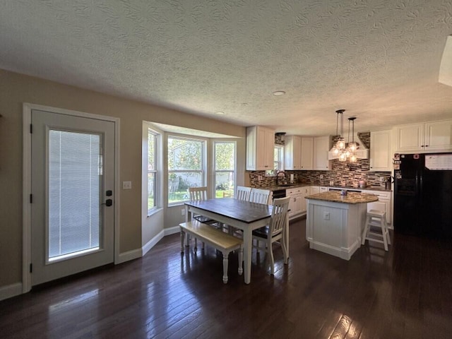 5321 Longshadow Dr, Westerville, OH 43081 - dining area with a textured ceiling, dark wood-type flooring, baseboards, and a chandelier