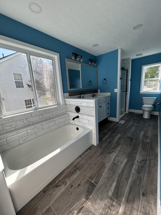 5321 Longshadow Dr, Westerville, OH 43081 - full bathroom featuring a bath, vanity, toilet, wood finished floors, and a textured ceiling