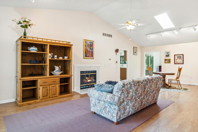 2049 Brandy Mill Ln, Dayton, OH 45459 - living room featuring light wood-style flooring, a glass covered fireplace, vaulted ceiling, ceiling fan, and rail lighting