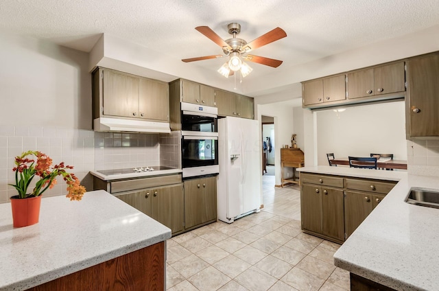 52 Amsterdam Ave, Columbus, OH 43207 - kitchen with white fridge with ice dispenser, stainless steel oven, under cabinet range hood, a ceiling fan, and decorative backsplash