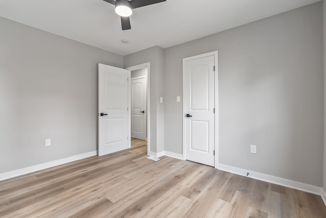 341 Woodland Ave, Columbus, OH 43203 - unfurnished bedroom with light wood-style flooring, baseboards, and a ceiling fan