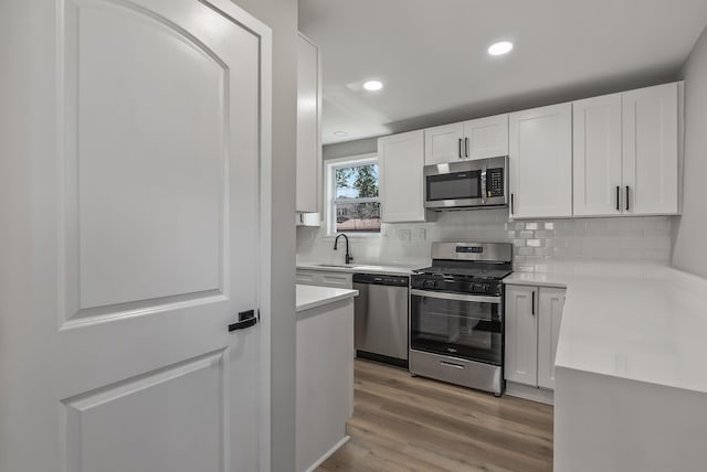 341 Woodland Ave, Columbus, OH 43203 - kitchen with appliances with stainless steel finishes, white cabinets, light countertops, tasteful backsplash, and a sink