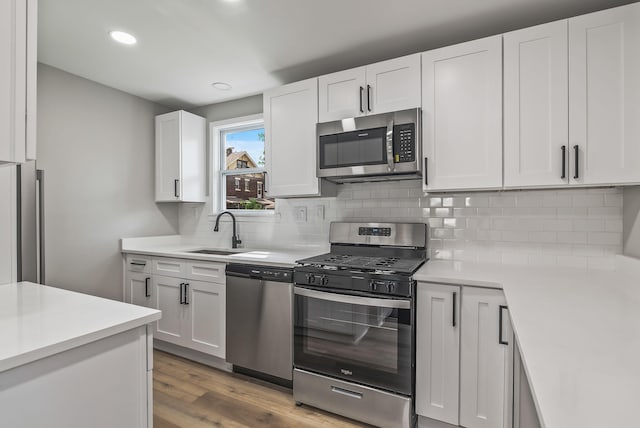 341 Woodland Ave, Columbus, OH 43203 - kitchen with stainless steel appliances, a sink, light countertops, white cabinetry, and recessed lighting
