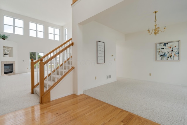 3899 Hampshire Ave, Powell, OH 43065 - unfurnished living room with stairway, a chandelier, carpet, and wood finished floors