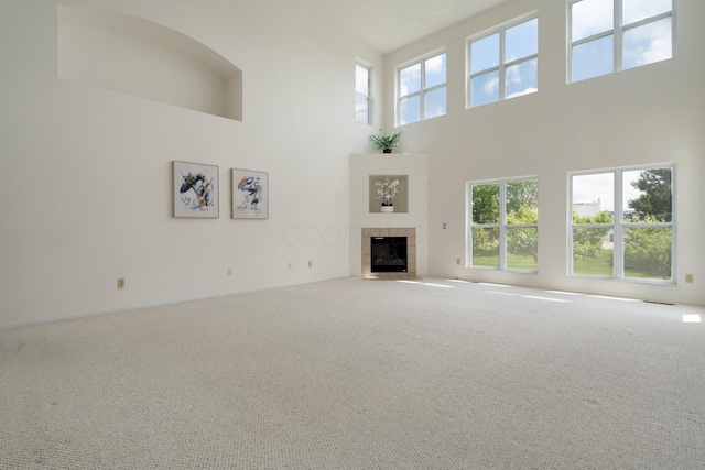3899 Hampshire Ave, Powell, OH 43065 - unfurnished living room with a high ceiling, a tile fireplace, carpet flooring, and baseboards