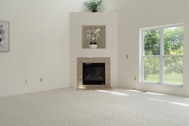 3899 Hampshire Ave, Powell, OH 43065 - unfurnished living room featuring carpet floors, healthy amount of natural light, a tiled fireplace, and baseboards