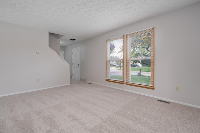 3456 Merrydawn Dr, Columbus, OH 43221 - unfurnished living room featuring light colored carpet, a textured ceiling, and baseboards