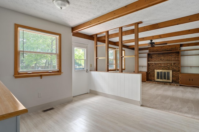 3456 Merrydawn Dr, Columbus, OH 43221 - unfurnished living room featuring beam ceiling, ceiling fan, a fireplace, wood finished floors, and a textured ceiling