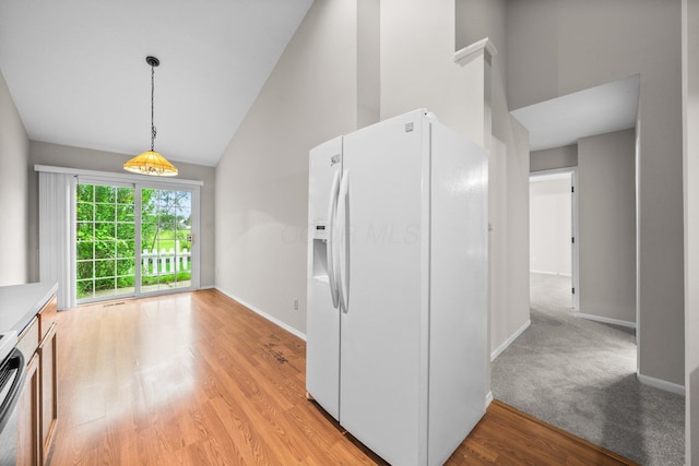 857 Village Dr, Delaware, OH 43015 - kitchen featuring white fridge with ice dispenser, baseboards, hanging light fixtures, light wood-type flooring, and high vaulted ceiling