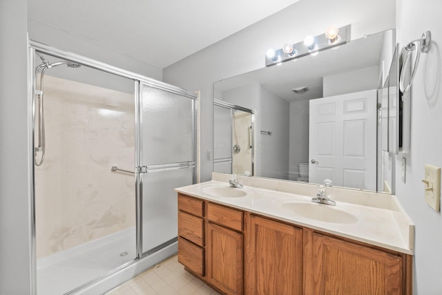 857 Village Dr, Delaware, OH 43015 - full bathroom with double vanity, a stall shower, tile patterned floors, and toilet