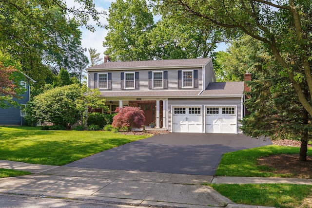 1332 Castleton Rd N, Columbus, OH 43220 - view of front of house with asphalt driveway, a chimney, a front lawn, and an attached garage