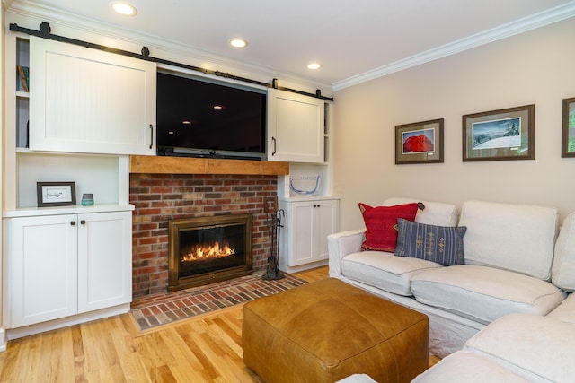 1332 Castleton Rd N, Columbus, OH 43220 - living area with crown molding, a barn door, light wood-style flooring, a brick fireplace, and recessed lighting