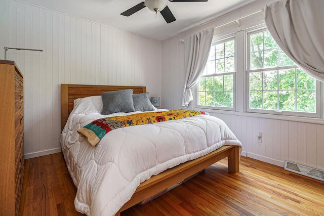 1332 Castleton Rd N, Columbus, OH 43220 - bedroom with wood finished floors, baseboards, wooden walls, and a ceiling fan