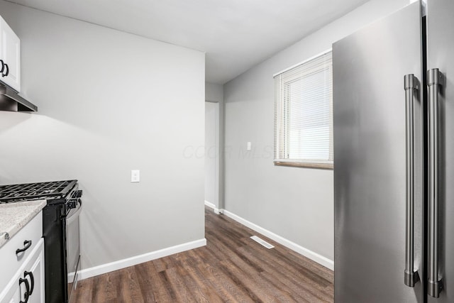 2280 Velma Ave, Columbus, OH 43211 - kitchen with stainless steel appliances, dark wood finished floors, white cabinets, under cabinet range hood, and baseboards