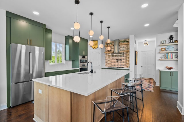 5781 Glendavon Loop, Dublin, OH 43016 - kitchen featuring stainless steel appliances, green cabinetry, wall chimney range hood, dark wood-style flooring, and tasteful backsplash