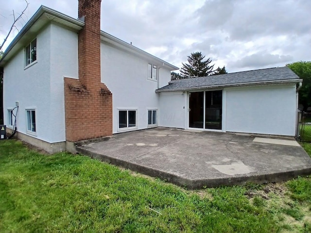 2489 Lipton Rd, Columbus, OH 43232 - rear view of house with stucco siding, a lawn, and a chimney