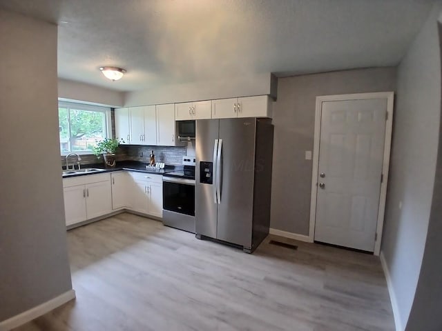 2489 Lipton Rd, Columbus, OH 43232 - kitchen featuring appliances with stainless steel finishes, white cabinetry, light wood-style flooring, and a sink