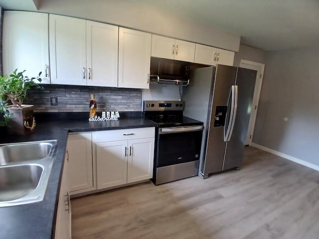 2489 Lipton Rd, Columbus, OH 43232 - kitchen with stainless steel appliances, white cabinets, light wood-style floors, backsplash, and dark countertops