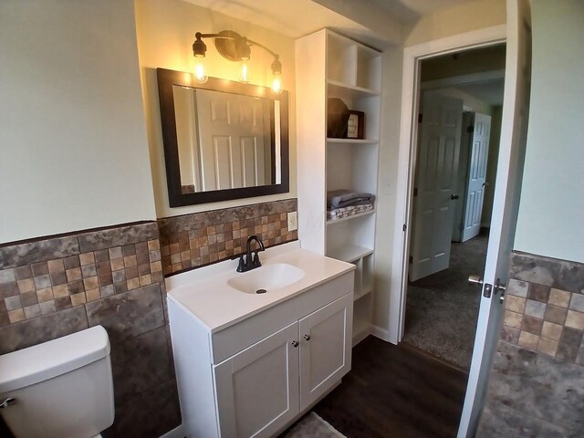 2489 Lipton Rd, Columbus, OH 43232 - bathroom featuring vanity, tile walls, toilet, built in features, and wainscoting