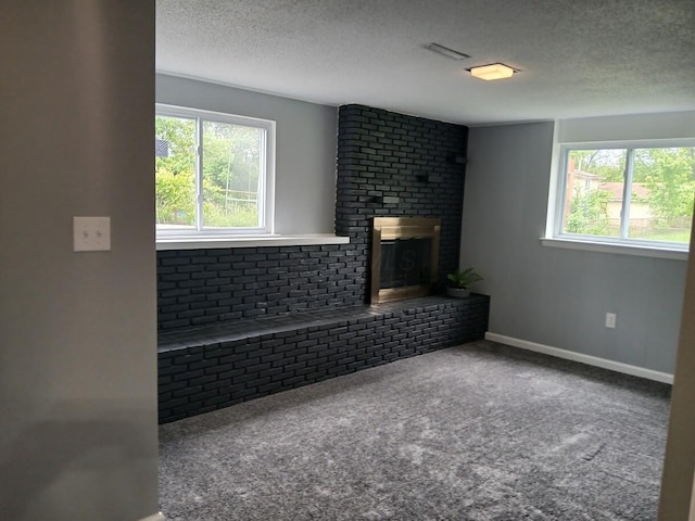 2489 Lipton Rd, Columbus, OH 43232 - unfurnished living room with plenty of natural light, a textured ceiling, a fireplace, carpet floors, and baseboards