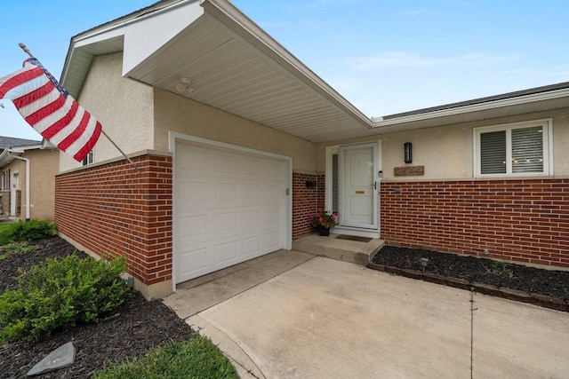 3544 Devin Rd, Grove City, OH 43123 - doorway to property featuring an attached garage, brick siding, driveway, and stucco siding