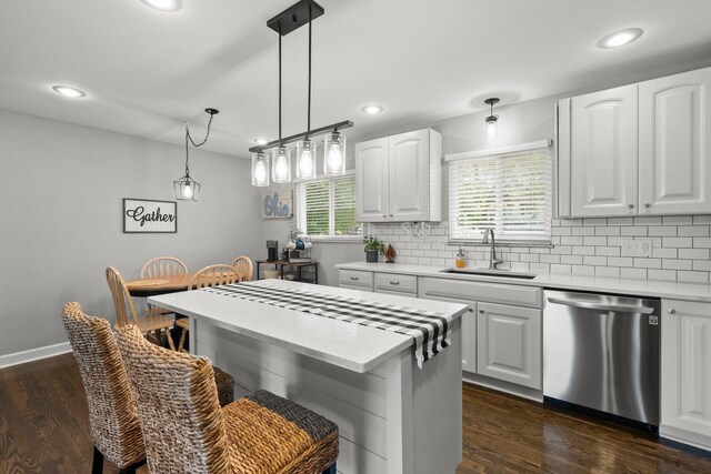 3544 Devin Rd, Grove City, OH 43123 - kitchen with dishwasher, a sink, backsplash, white cabinetry, and a kitchen breakfast bar