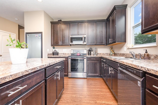 1705 Bent Creek Dr, Lancaster, OH 43130 - kitchen with appliances with stainless steel finishes, light countertops, light wood-type flooring, and dark brown cabinetry