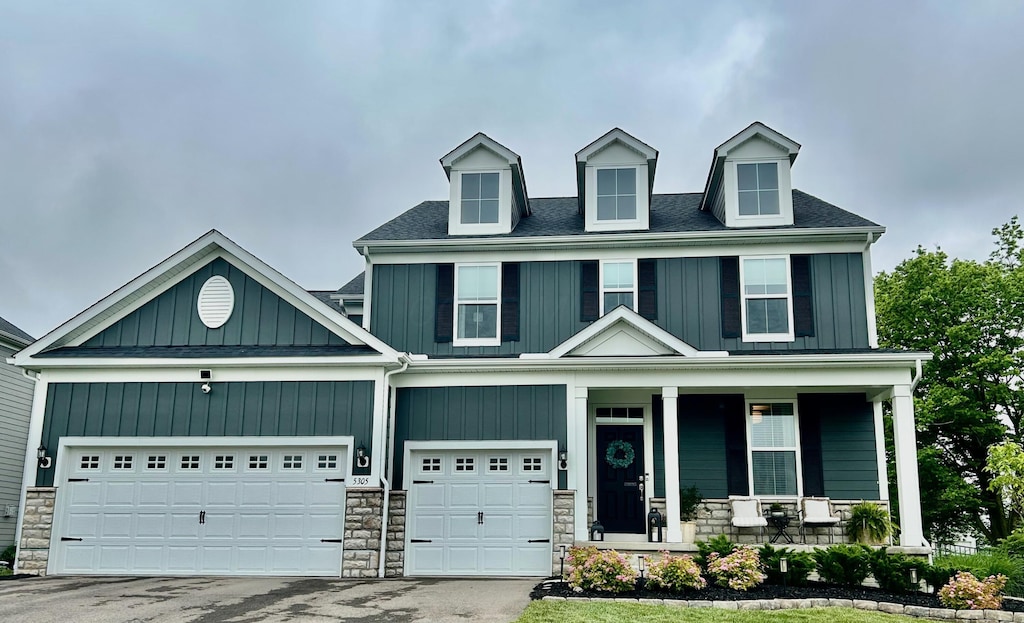 5305 Tarlton Blvd, Hilliard, OH 43026 - view of front facade featuring a porch, board and batten siding, and stone siding
