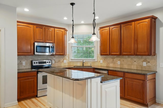 273 Blue Jacket Cir, Pickerington, OH 43147 - kitchen featuring stainless steel appliances, a sink, dark stone countertops, pendant lighting, and light wood-style flooring