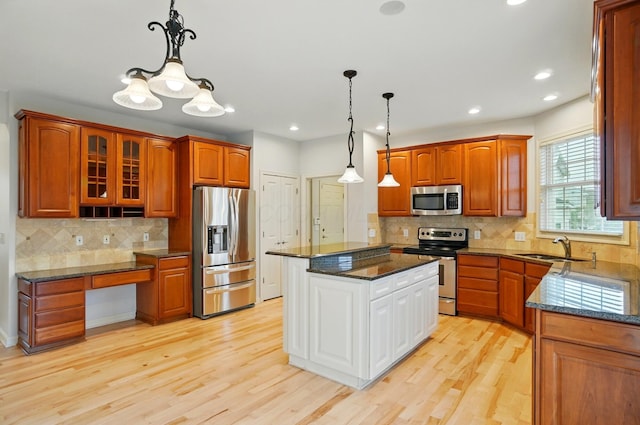 273 Blue Jacket Cir, Pickerington, OH 43147 - kitchen with appliances with stainless steel finishes, a sink, glass insert cabinets, backsplash, and light wood-style floors