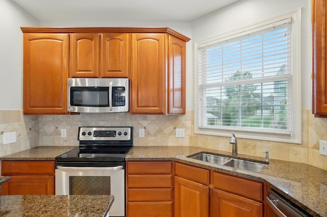 273 Blue Jacket Cir, Pickerington, OH 43147 - kitchen featuring stainless steel appliances, a sink, stone counters, backsplash, and brown cabinets