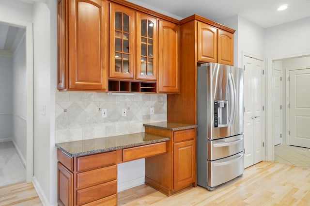 273 Blue Jacket Cir, Pickerington, OH 43147 - kitchen with stainless steel fridge, dark stone countertops, glass insert cabinets, decorative backsplash, and brown cabinetry