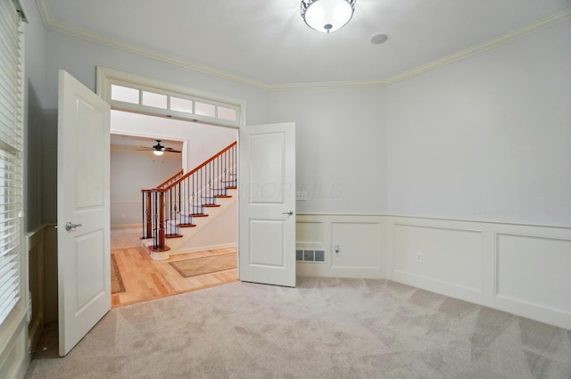 273 Blue Jacket Cir, Pickerington, OH 43147 - carpeted empty room featuring crown molding, stairs, ceiling fan, wainscoting, and a decorative wall