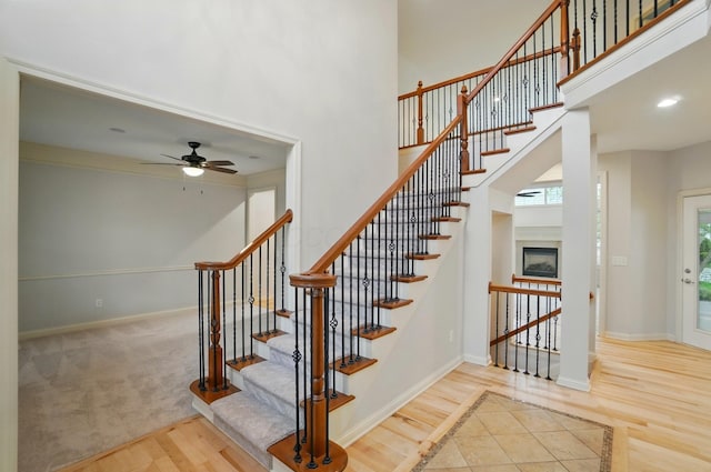 273 Blue Jacket Cir, Pickerington, OH 43147 - stairs featuring wood finished floors, a towering ceiling, a ceiling fan, and baseboards
